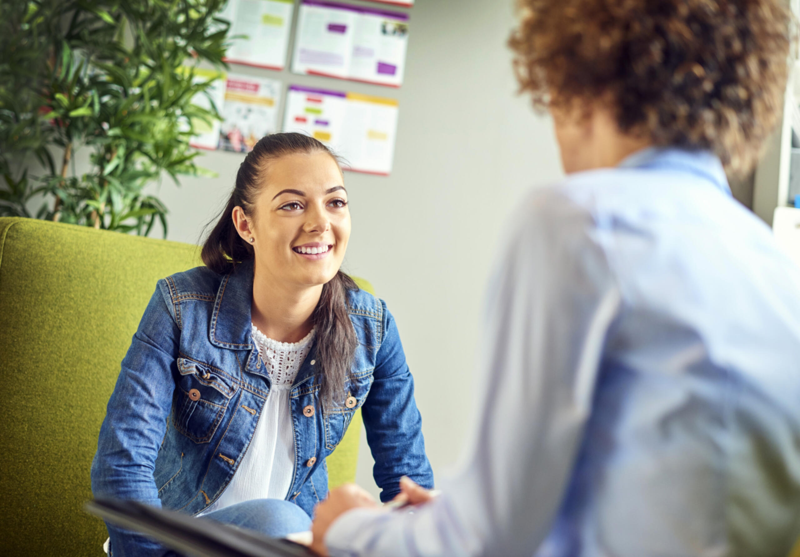 Young careers guidance counsellor sitting and helping a student while smiling